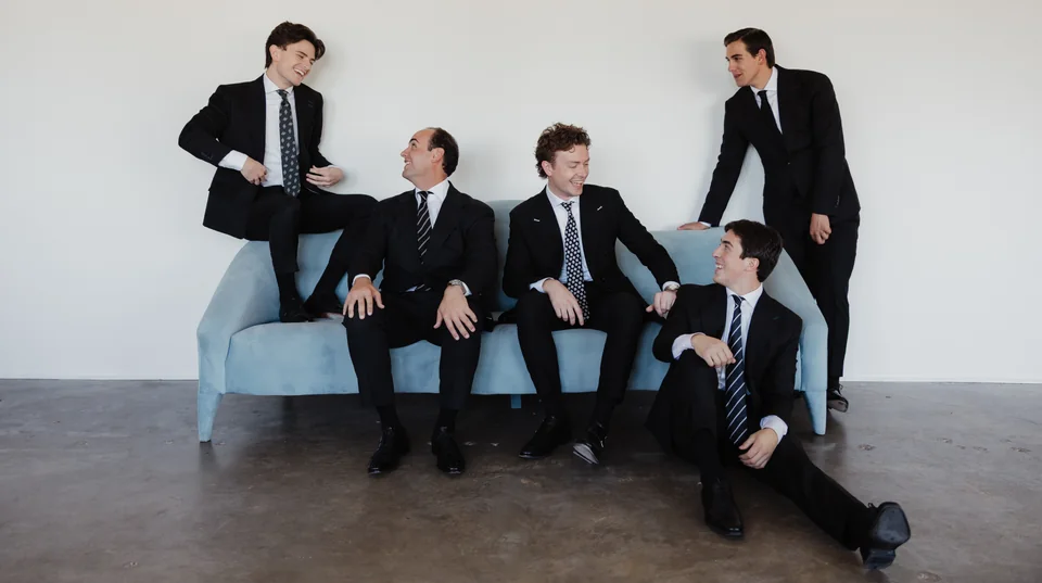 A candid group composition in custom suits.