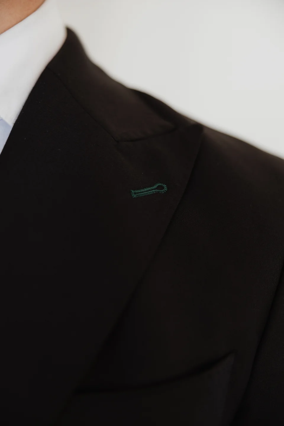 Dark jacket lapel and buttonhole detail.