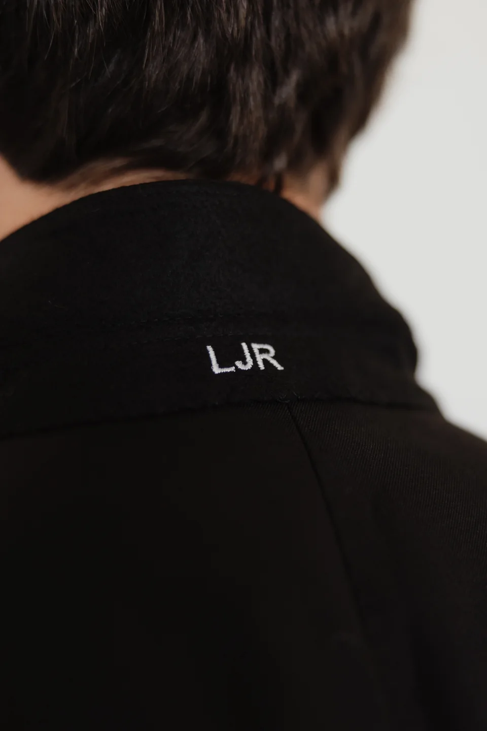 Personalized lettering beneath a jacket collar.