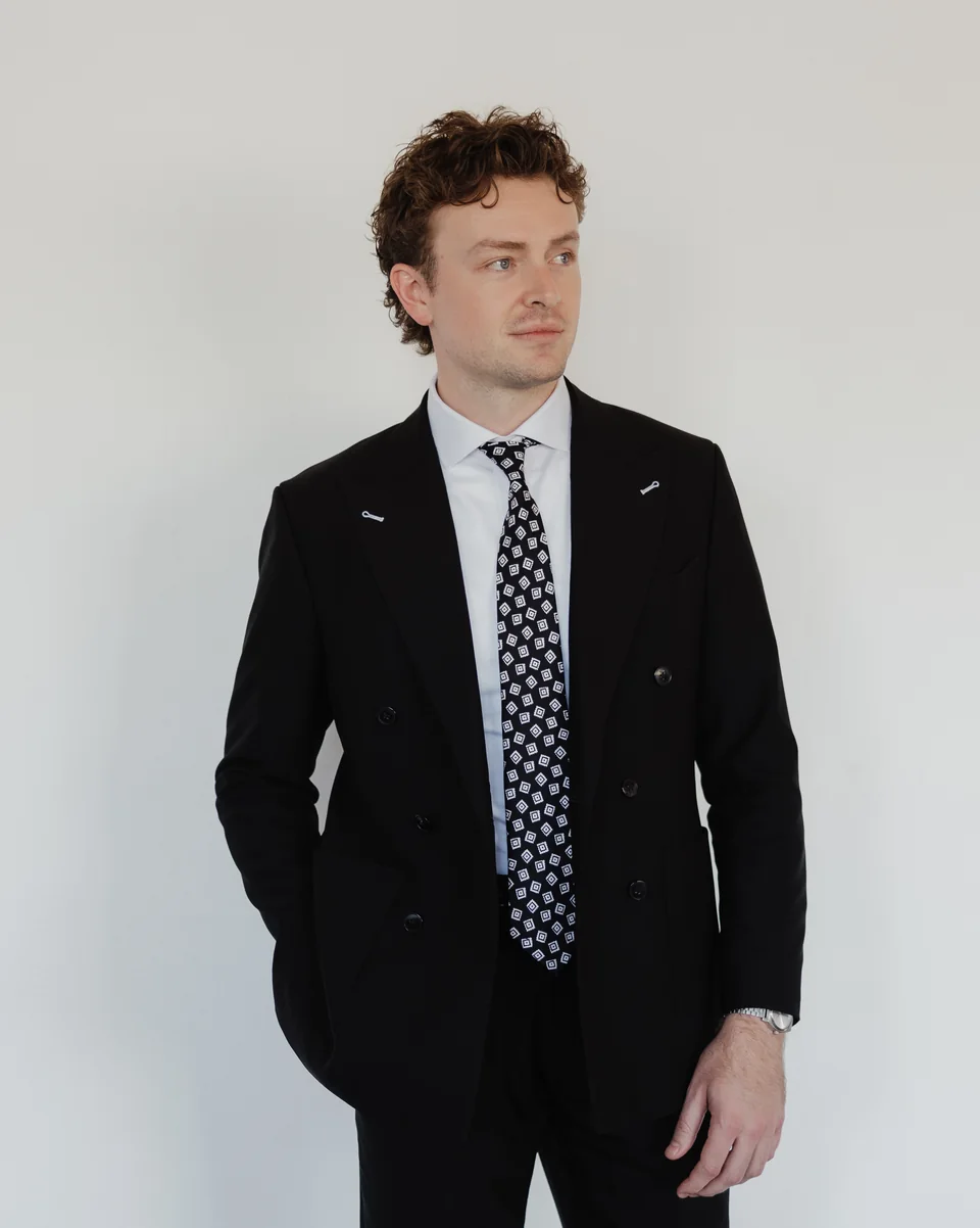 Black double-breasted suit with a patterned tie.