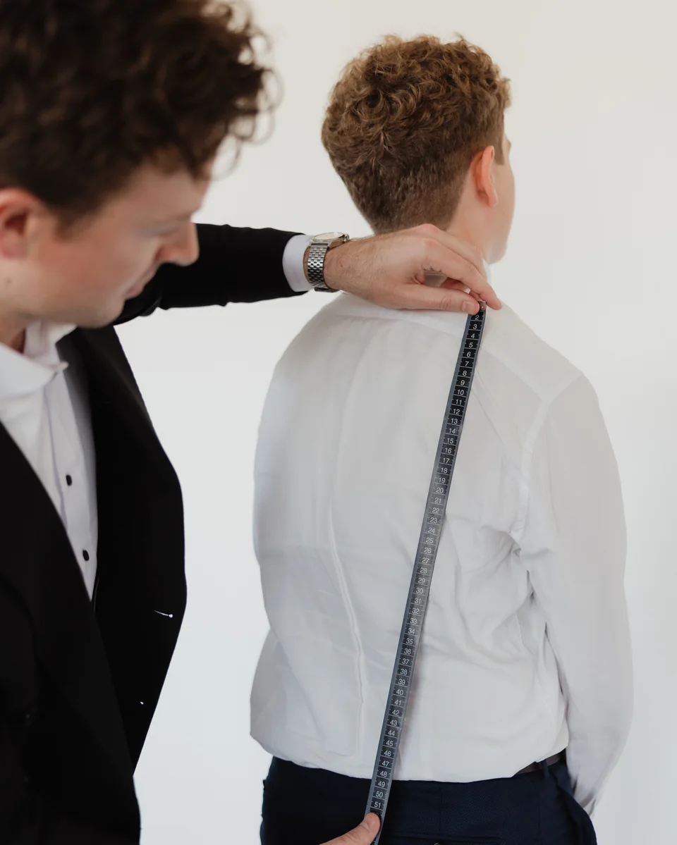 Measuring a customer for a custom suit.