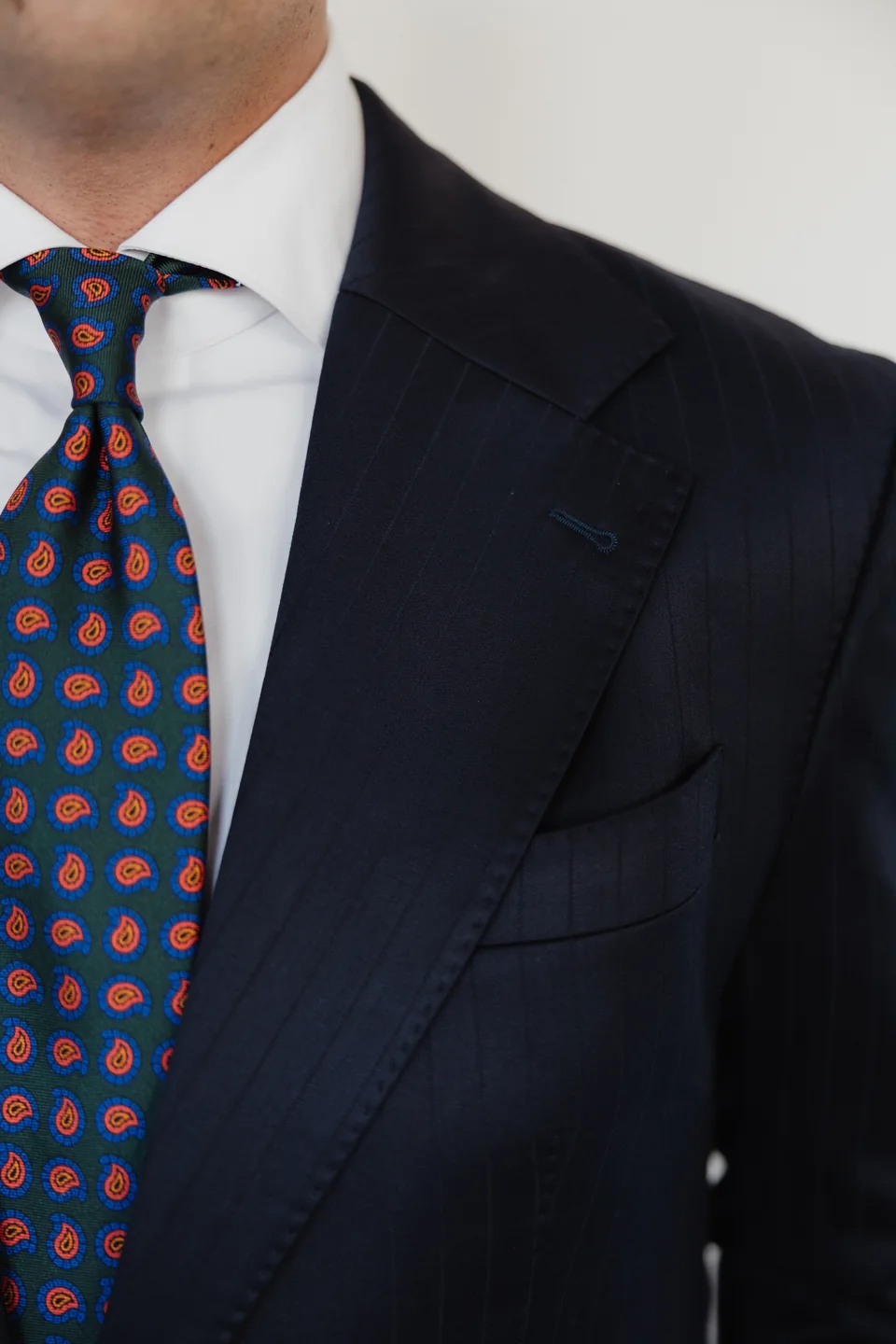 Navy lapels and colorful patterned tie detail.
