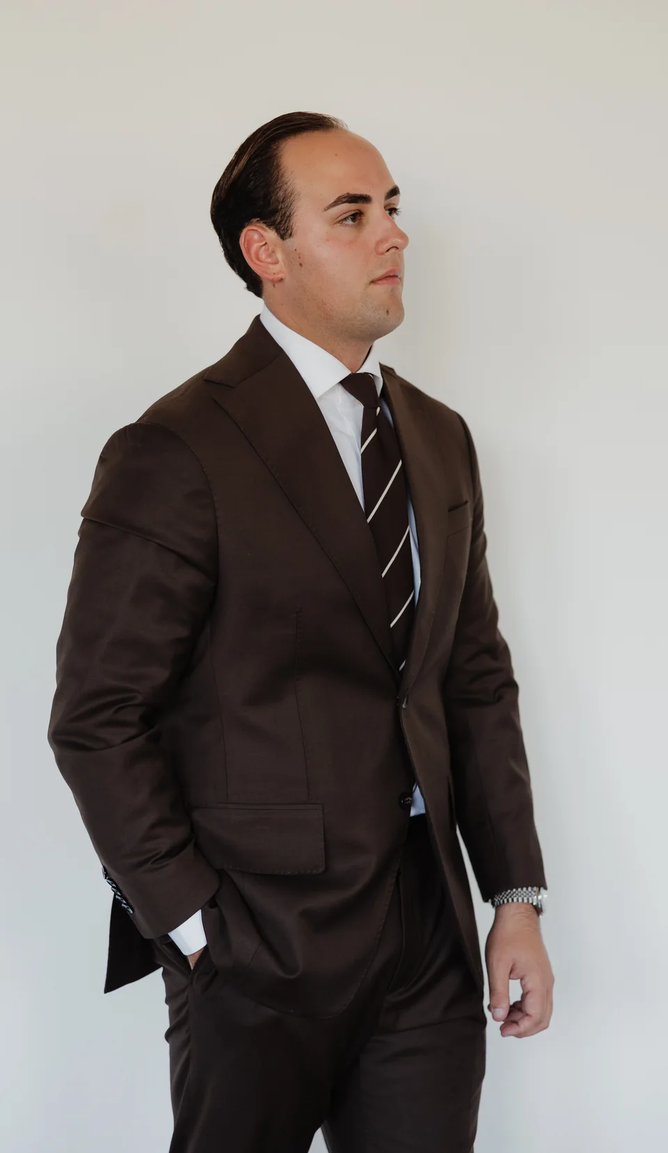 Brown suit with a striped tie.