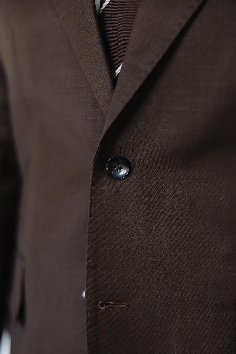 Brown suit jacket button and fabric detail.