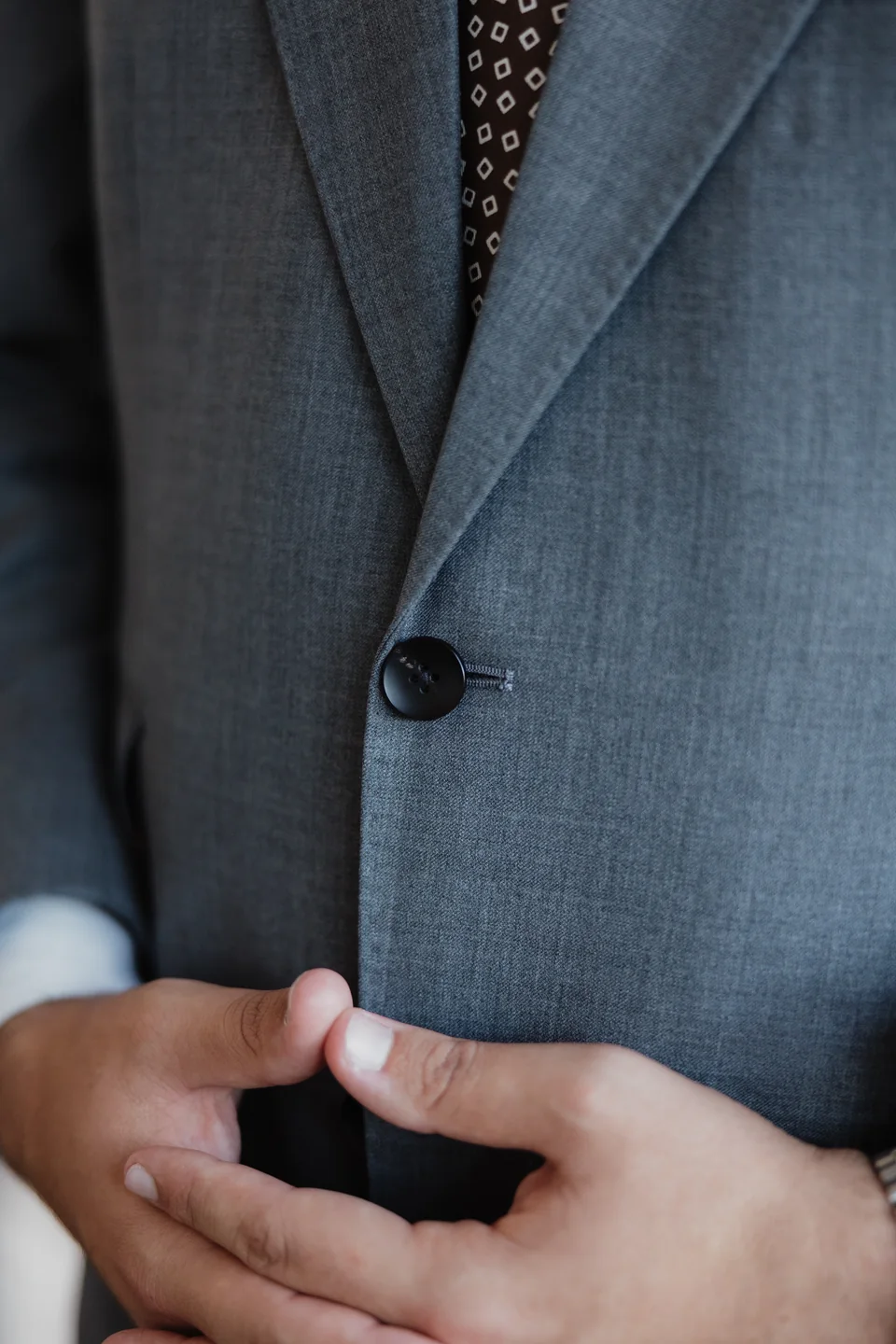 Gray jacket front, buttons and fabric detail.