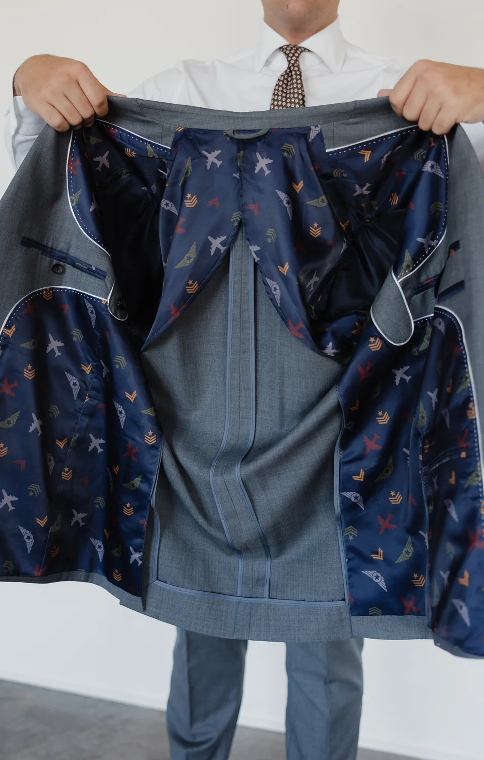 Gray jacket opened to show a colorful interior lining.