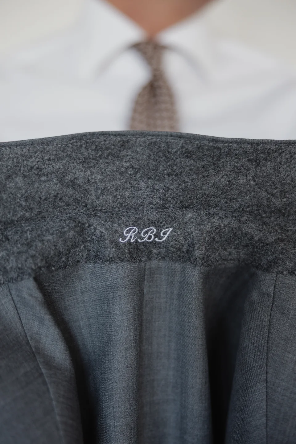 Personalized interior detail inside a gray suit jacket.